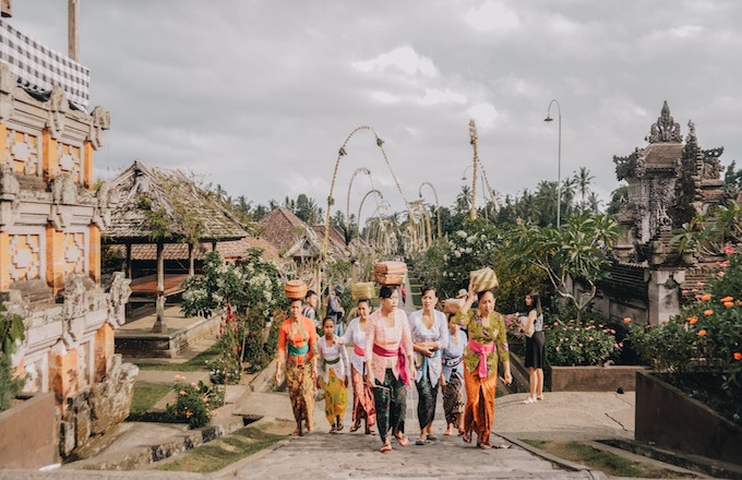 Women in traditional dress walking on a path in Bali, Indonesia