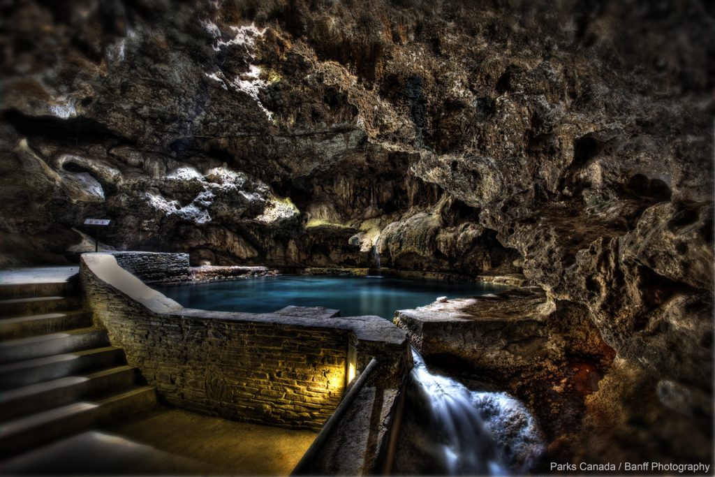 Inside at the Cave and Basin - a pool of water surrounded by jagged rocks