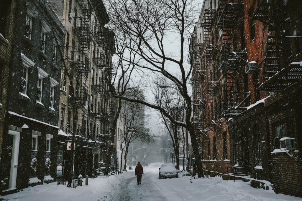 Person walking down a street covered with snow in New York City