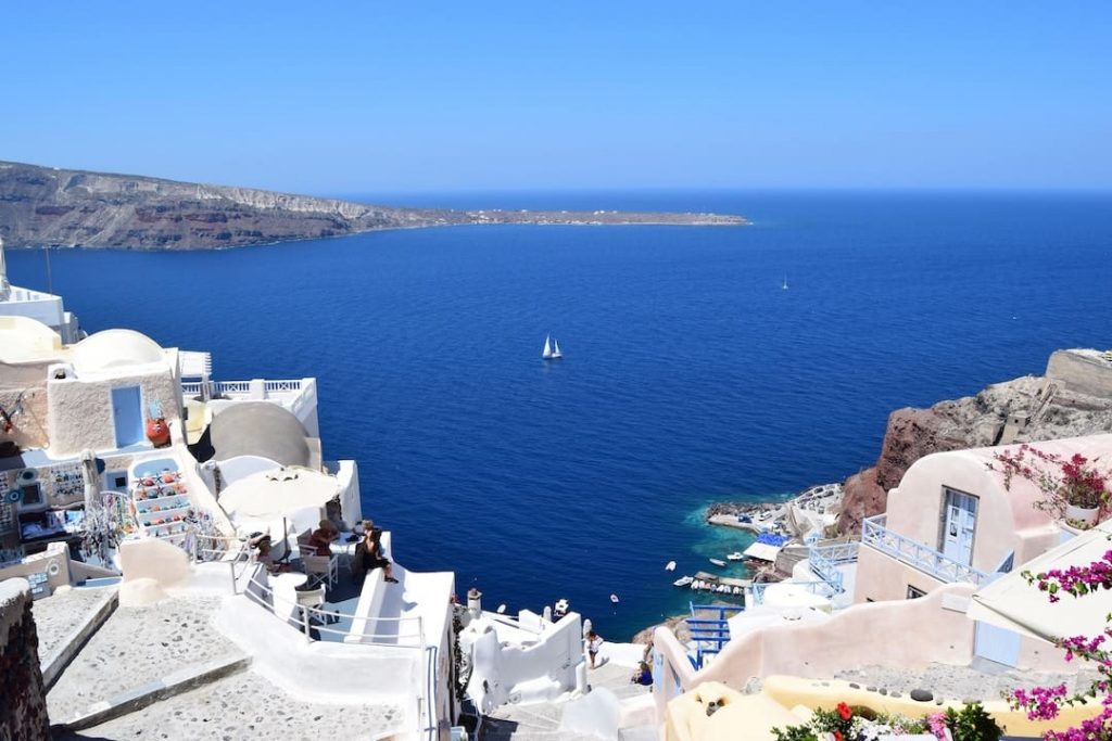 A sailboat floating in the sea off the coast of Santorini, Greece