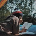 A woman reading while laying in a tent in Vietnam