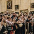 Crowd of tourists trying to take photos of the Mona Lisa in the Louvre in Paris