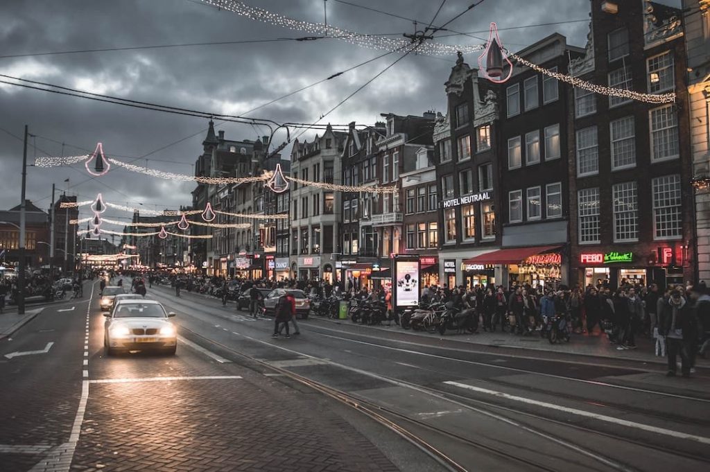 A road and sidewalks filled with people in Amsterdam, Netherlands