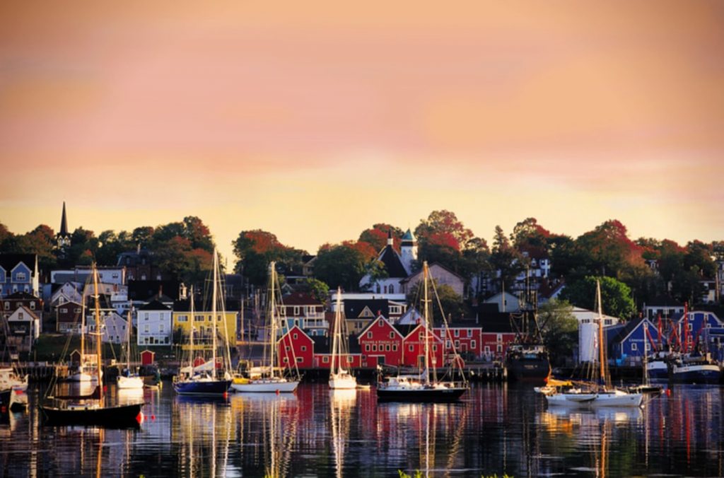 a colourful little village alongside a harbour with boats in it
