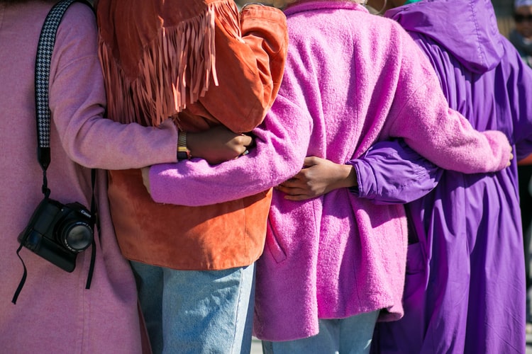 a group of women with their arms around one another