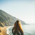 Woman standing in front of a bay with her back facing camera