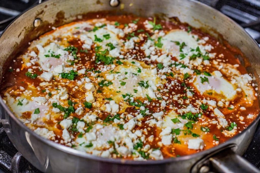 Shakshuka in a skillet topped with feta cheese