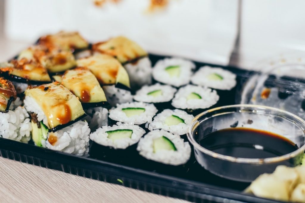 Take away sushi and soy sauce in a black container