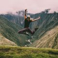Woman jumping at the top of Machu Picchu in Peru