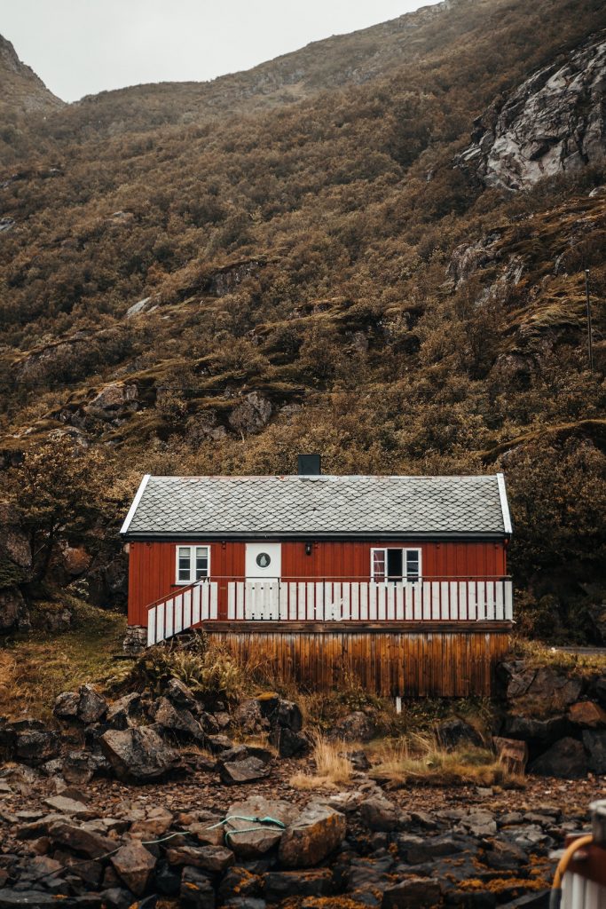 Red cabin surrounded by hills and rocks in Sweden