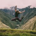 Woman jumping at the top of Machu Picchu in Peru