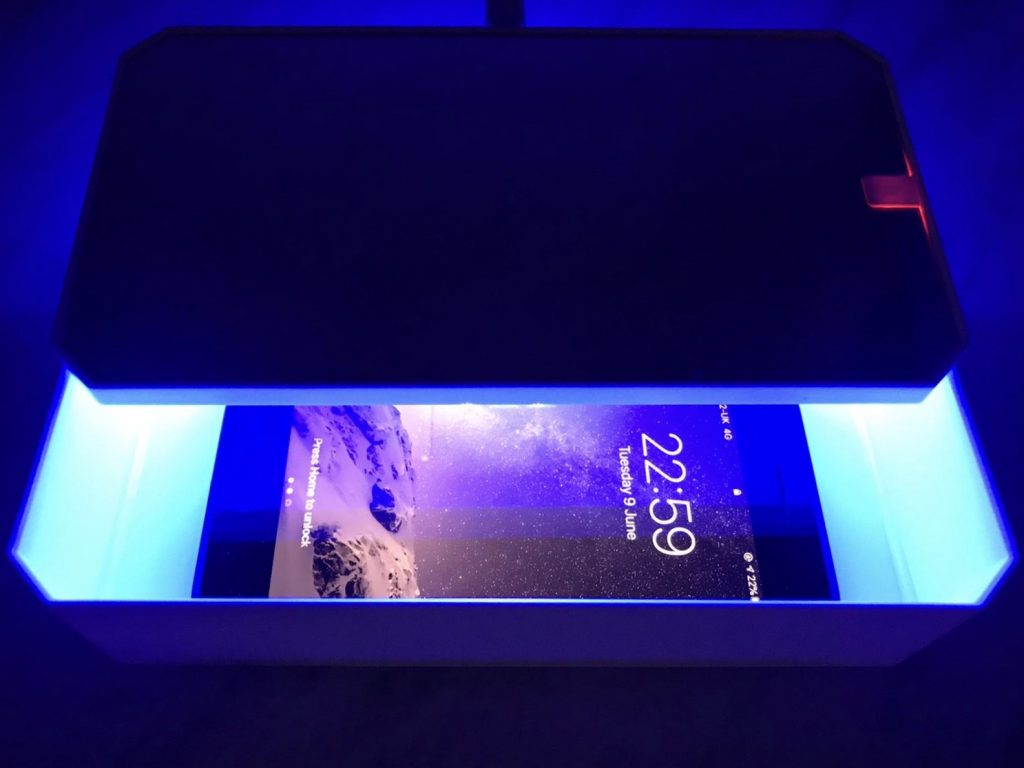 useful travel accessories: a box with a uv light in it cleaning a phone