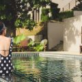 Woman sitting on the edge of a hotel pool in Thailand