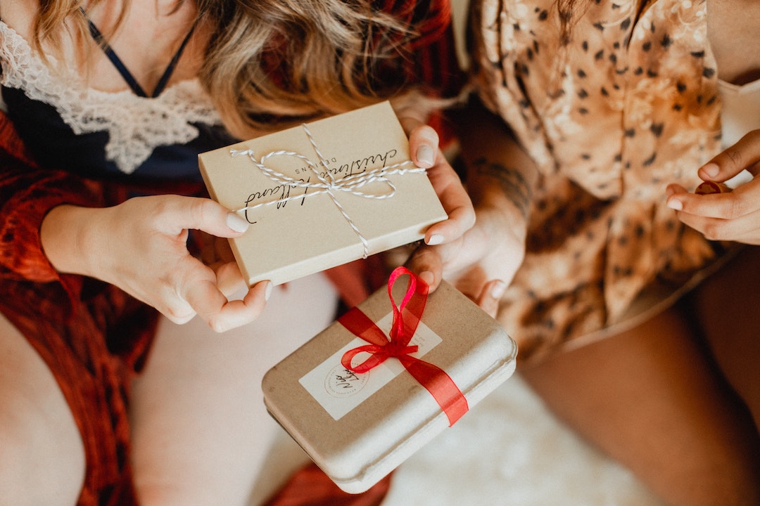 Two friends exchanging holiday gifts
