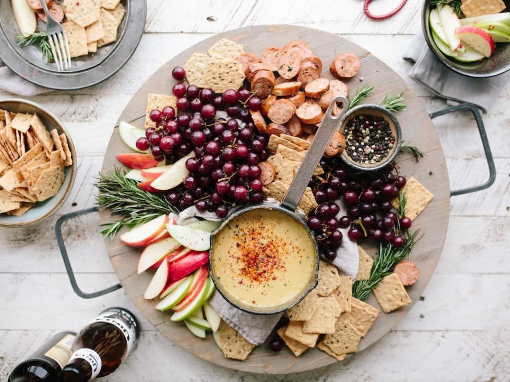Cheese board with meat, fruit, and crackers