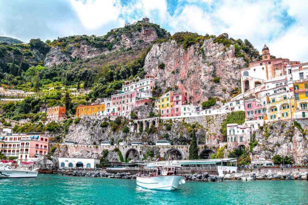 View from the water of the colorful hillside houses of the Amalfi Coast, Italy with a small boat in the foreground