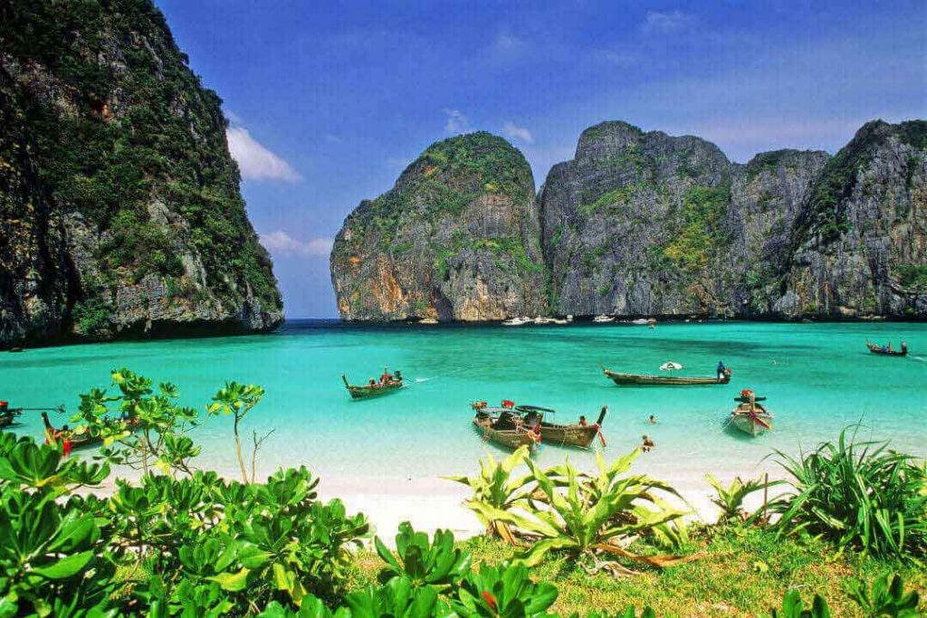 Thai long-tail boats float in the famous Maya Bay, which served as the filming location for the movie The Beach.