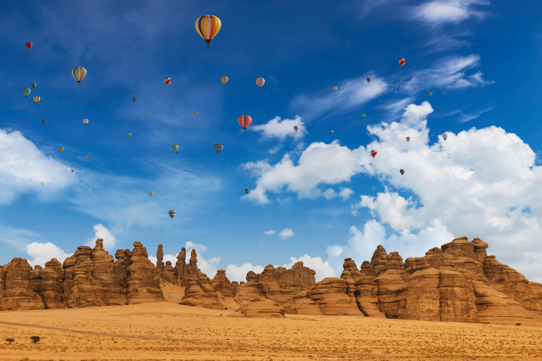 Hot air balloons flying in the blue sky of AlUla, Saudi Arabia