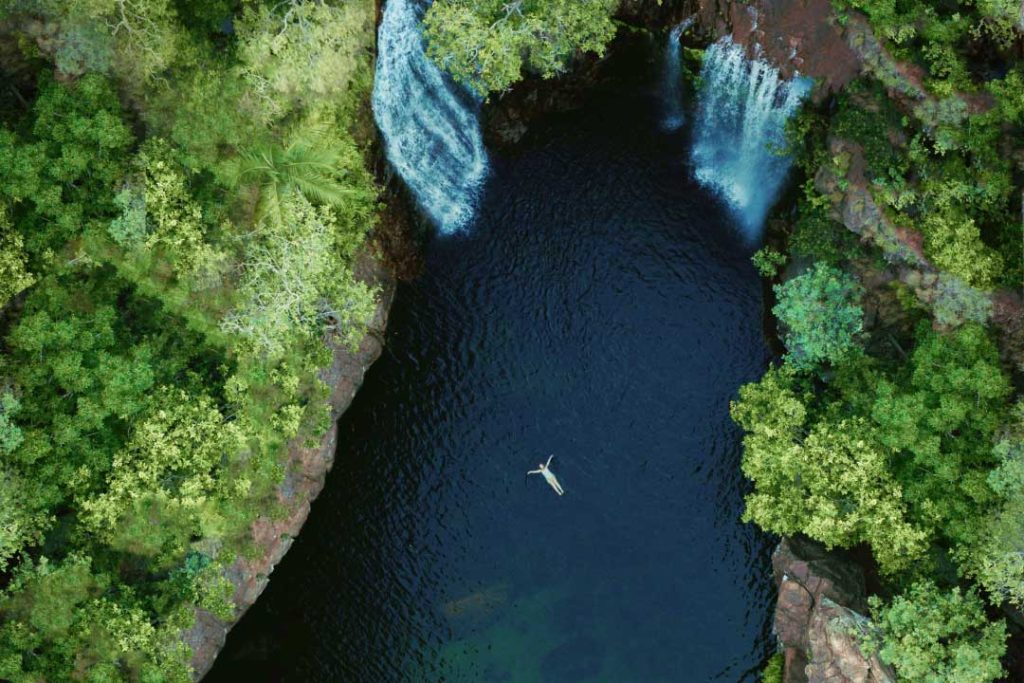 A person floats in the water near Florence Falls, Litchfield National Park, Australia. 
